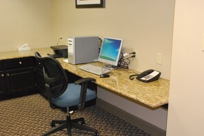 A hotel office with a desktop computer, a laptop, a telephone, and a chair. - Holiday Inn Express Bloomington West by IHG (Bloomington)