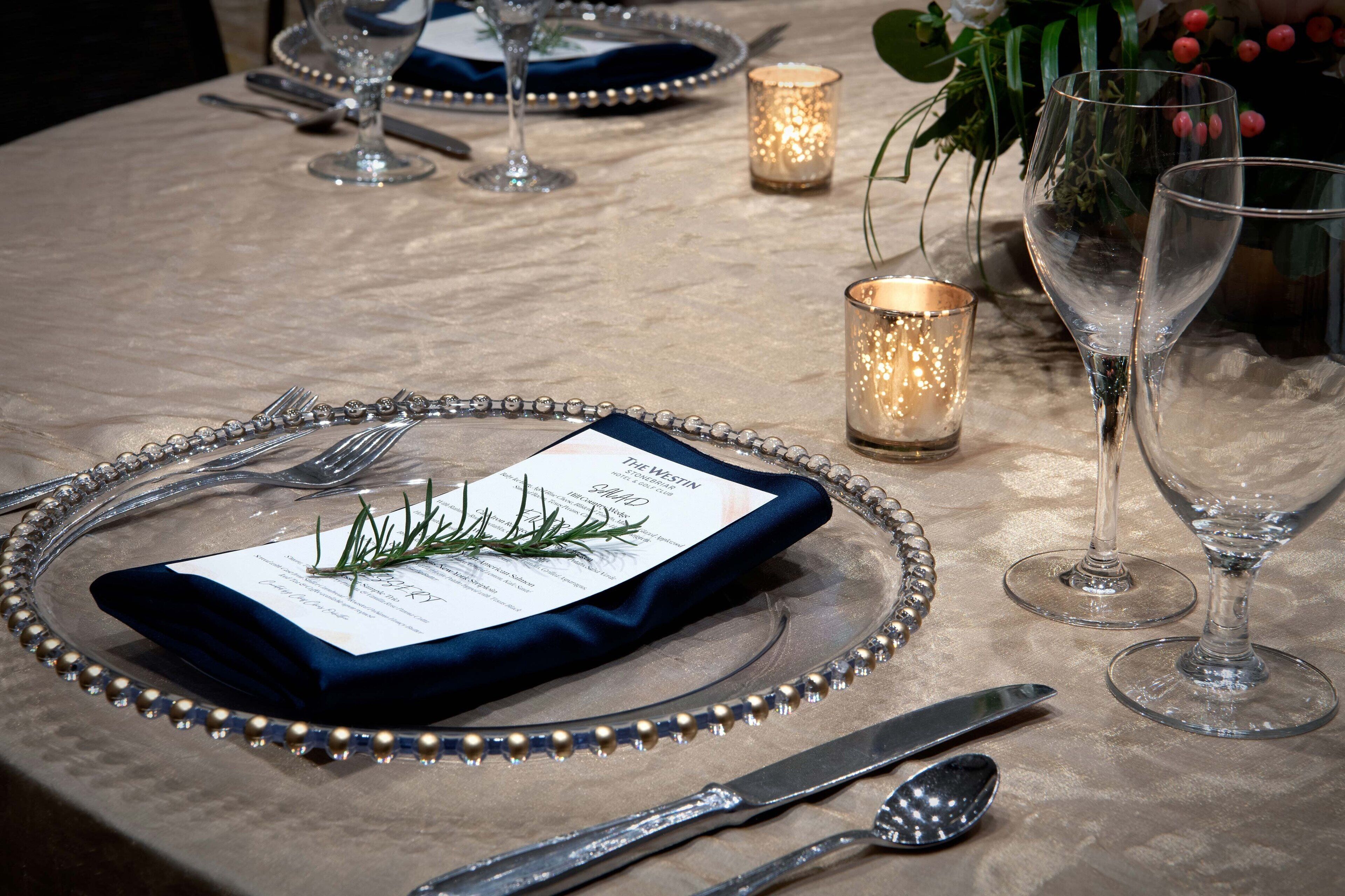 A table set for a meal with a menu, cutlery, and candlelight.