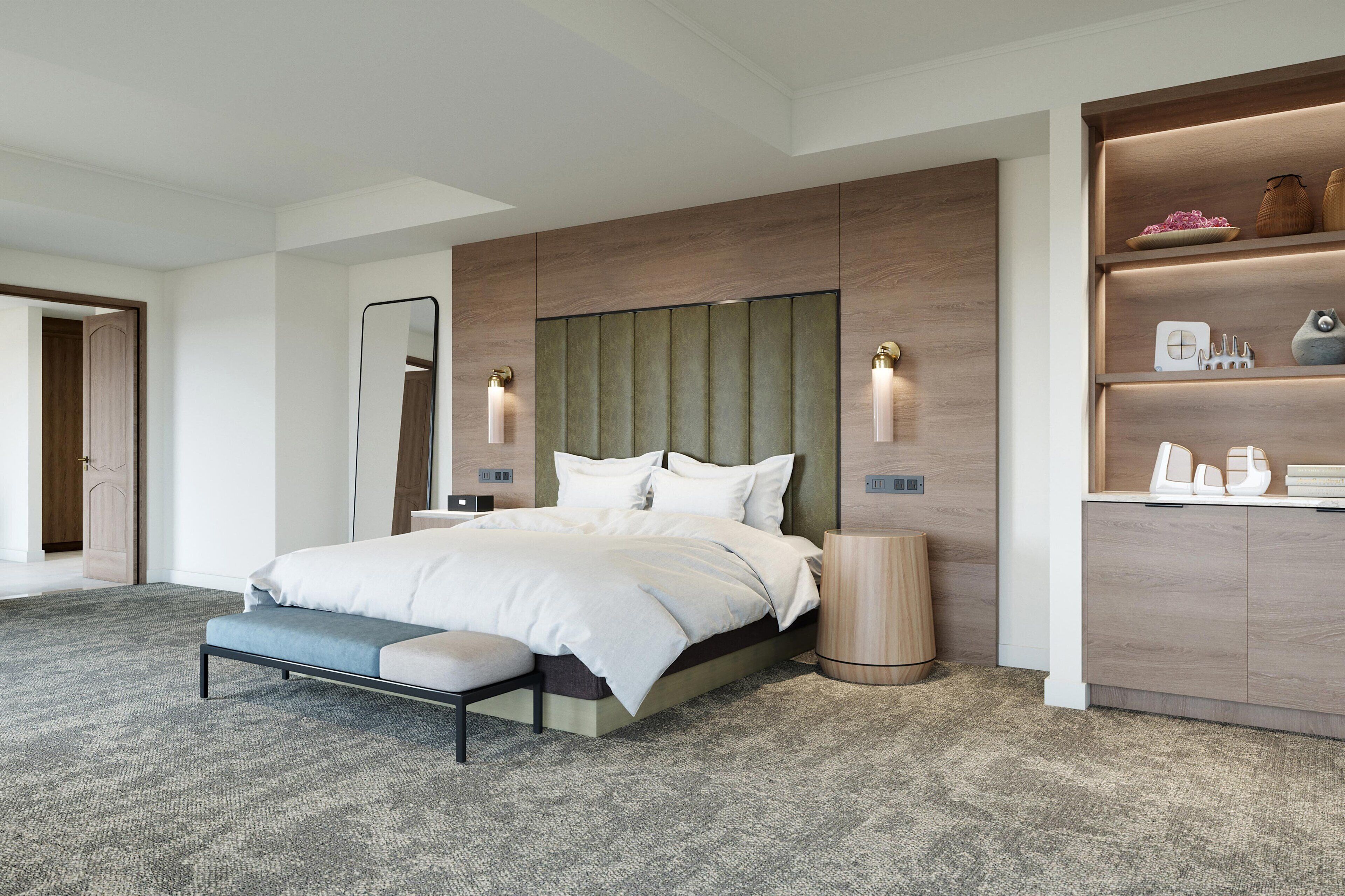 A modern bedroom with a large bed, a bench, a bedside table, a mirror, and a built-in shelf with decorative items.