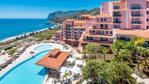 Un resort con una grande piscina, diversi balconi e vista sull'oceano.