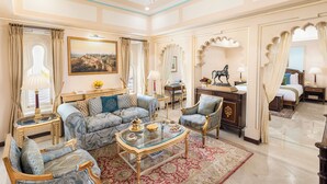 A spacious living room with a sofa set, a coffee table, and a dining area. - Taj Fateh Prakash Palace (Udaipur)