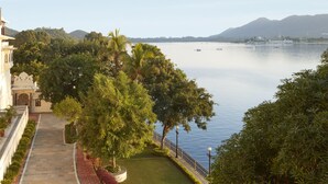 A pathway leading to a body of water with a view of distant hills. - Taj Fateh Prakash Palace (Udaipur)