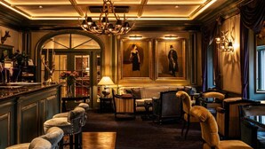 A luxurious lobby with a grand chandelier, elegant seating, and framed portraits on the walls. - Grand Palace Hotel – Small Luxury Hotels of the World (Riga)