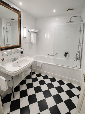 Un baño con lavamanos, espejo y bañera.