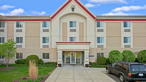A multi-story hotel with a central entrance, a red roof, and a number '3000' on the facade. - MainStay Suites Northbrook Wheeling (Wheeling)