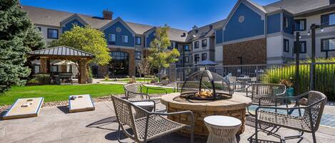 A patio area with outdoor seating, a fire pit, and a gazebo.