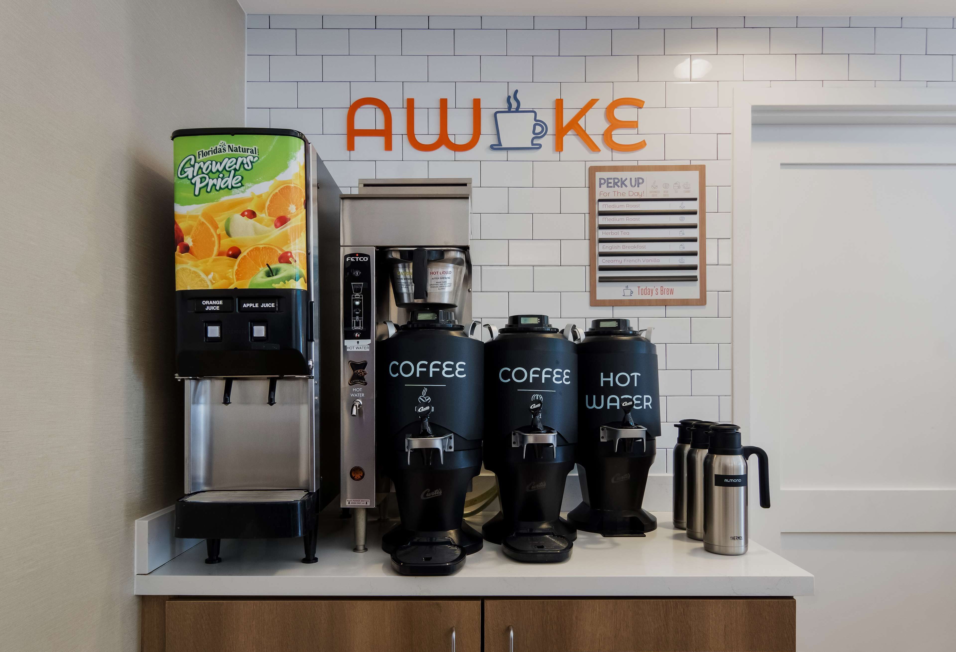 Una estación de café con una máquina de café, tres dispensadores de café y un dispensador de agua.