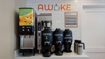 Una estación de café con una máquina de café, tres dispensadores de café y un dispensador de agua.