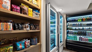 Una tienda de comestibles con estantes llenos de refrigerios, bebidas y productos envasados.