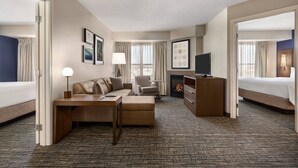 Ein Hotelzimmer mit Bett, Sofa, Schreibtisch, Fernseher und Kamin.