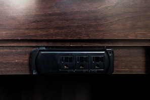 A wooden surface with a black electrical outlet panel.