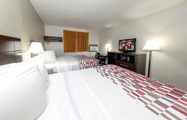 A hotel room with two beds, a television, a desk, and a window with curtains. - Red Roof Inn Culpeper (Culpeper)