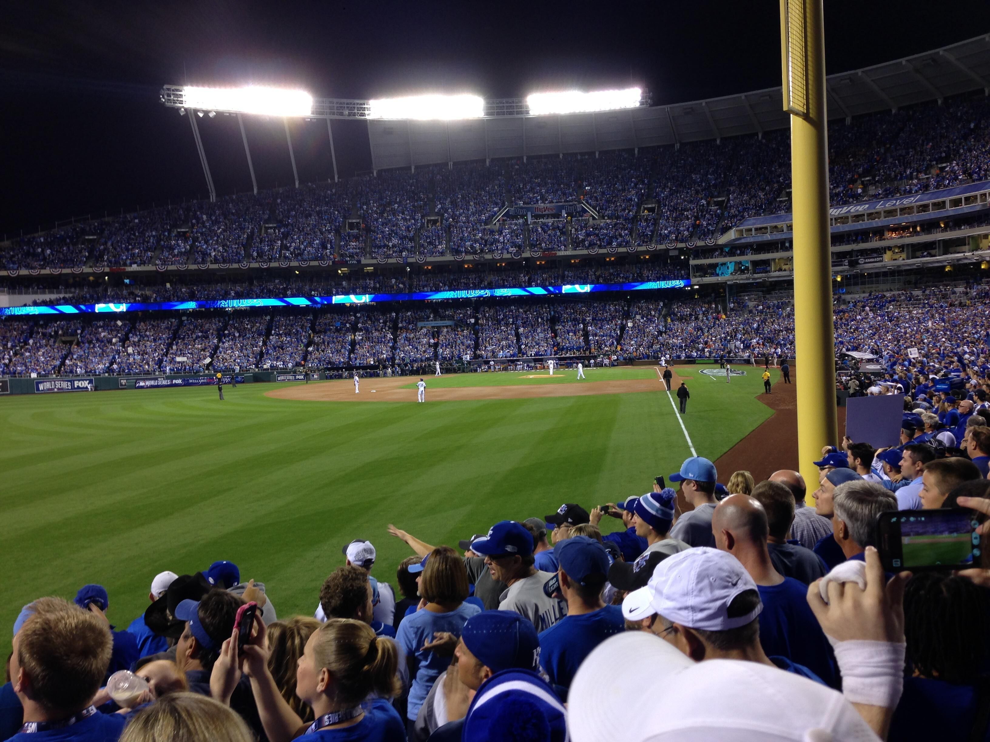 Un stade rempli de spectateurs, un terrain de baseball et une foule nombreuse.