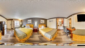 Habitación de hotel con dos camas, un escritorio, una silla, un televisor y un microondas.