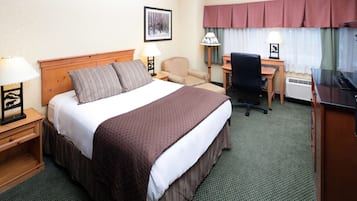 Une chambre d’hôtel avec un grand lit, un bureau, une chaise et un téléviseur.