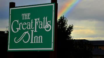 A sign for "The Great Falls Inn" with a rainbow in the background.