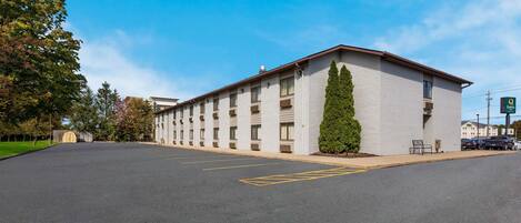 A multi-story hotel with a parking lot in front.