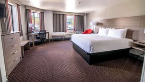 A hotel room with a large bed, a desk with a chair, a TV, and a window with curtains. - Best Western Helena/Capitol Hotel (Helena)