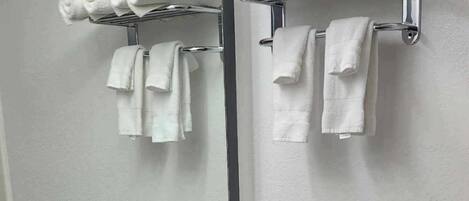 A bathroom with a sink, mirror, towel rack, and toilet.