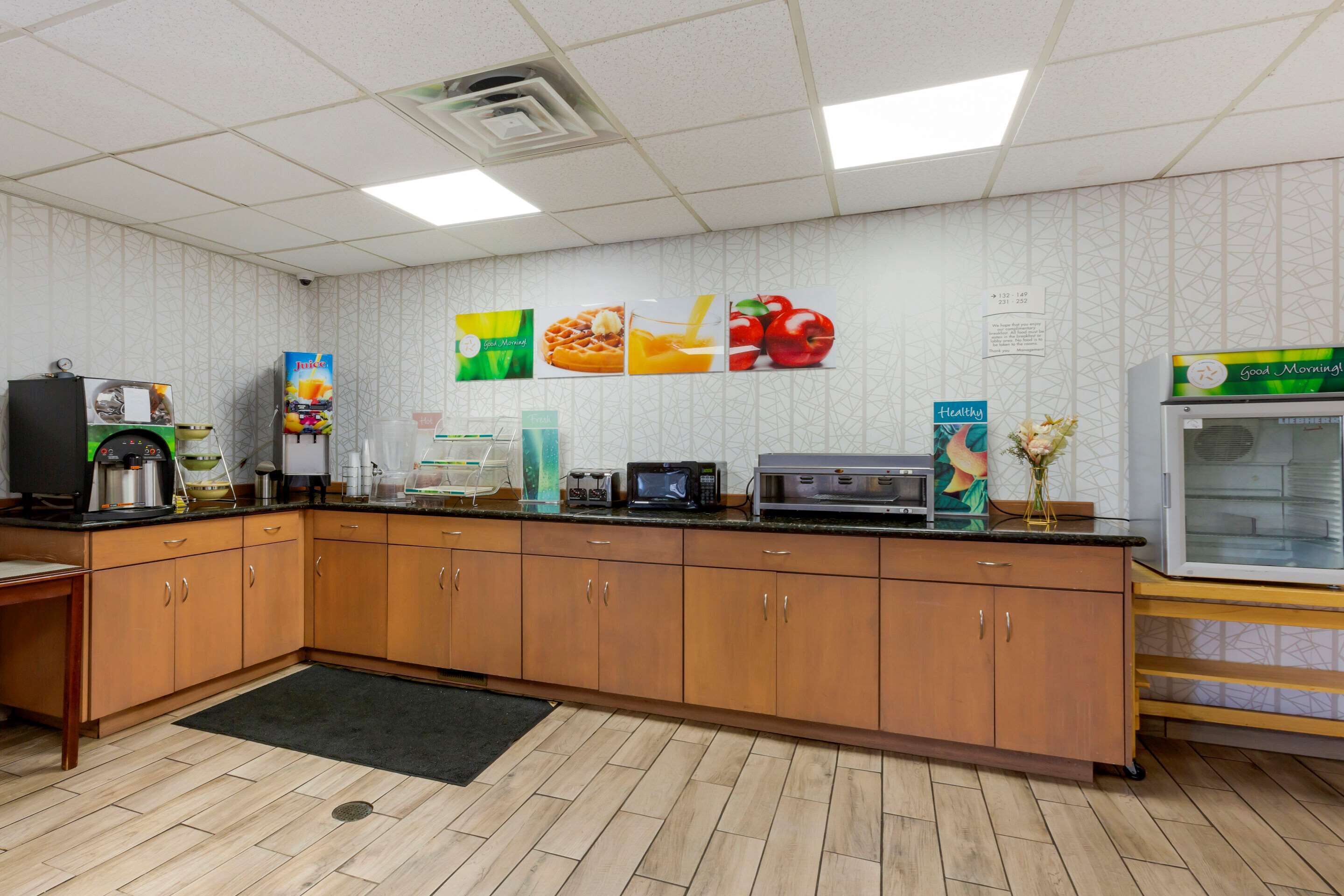 A kitchen with wooden cabinets, a microwave, a coffee machine, and a refrigerator.