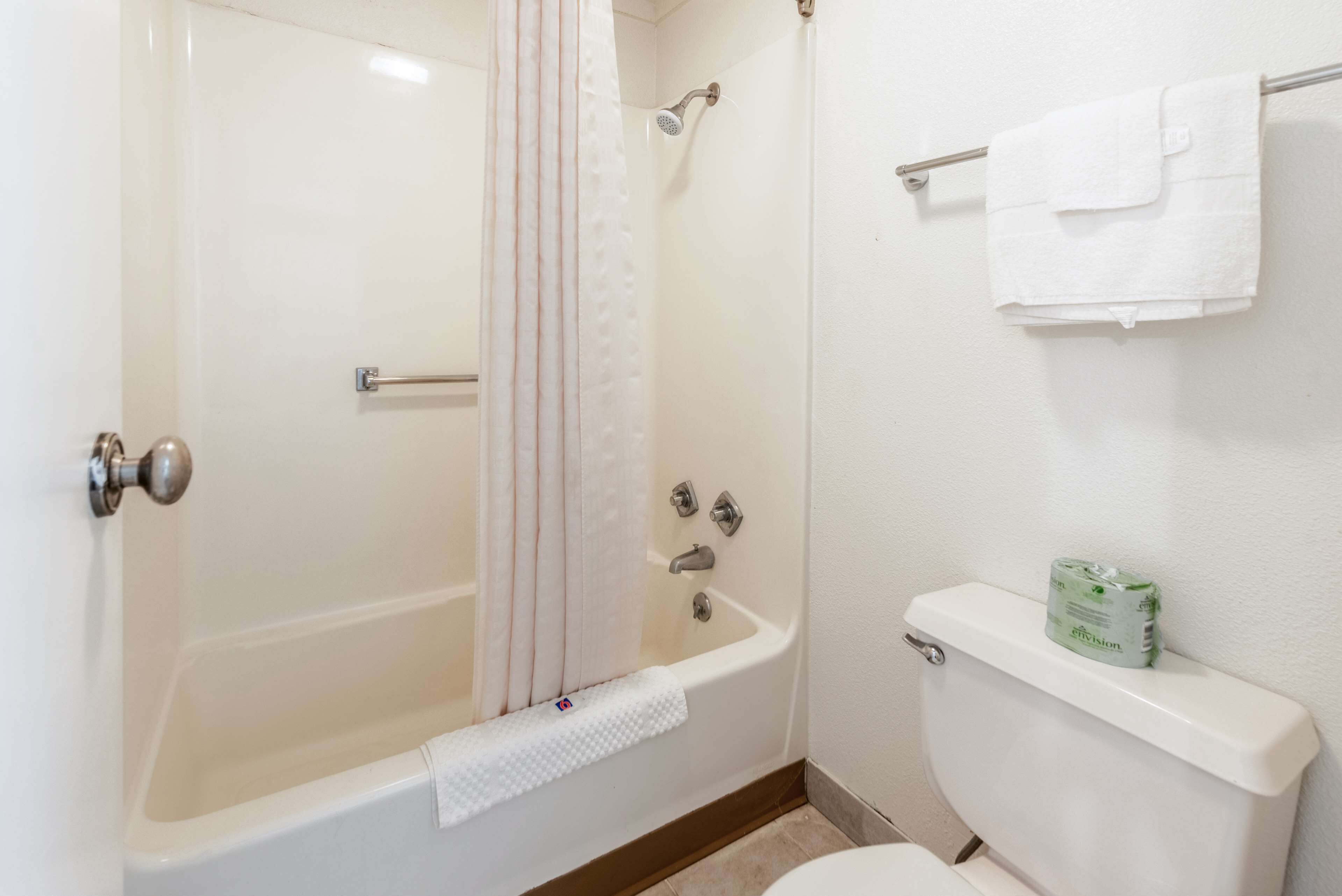 Une salle de bain équipée d’une baignoire, d’une douche, de toilettes et d’un porte-serviettes avec une serviette.
