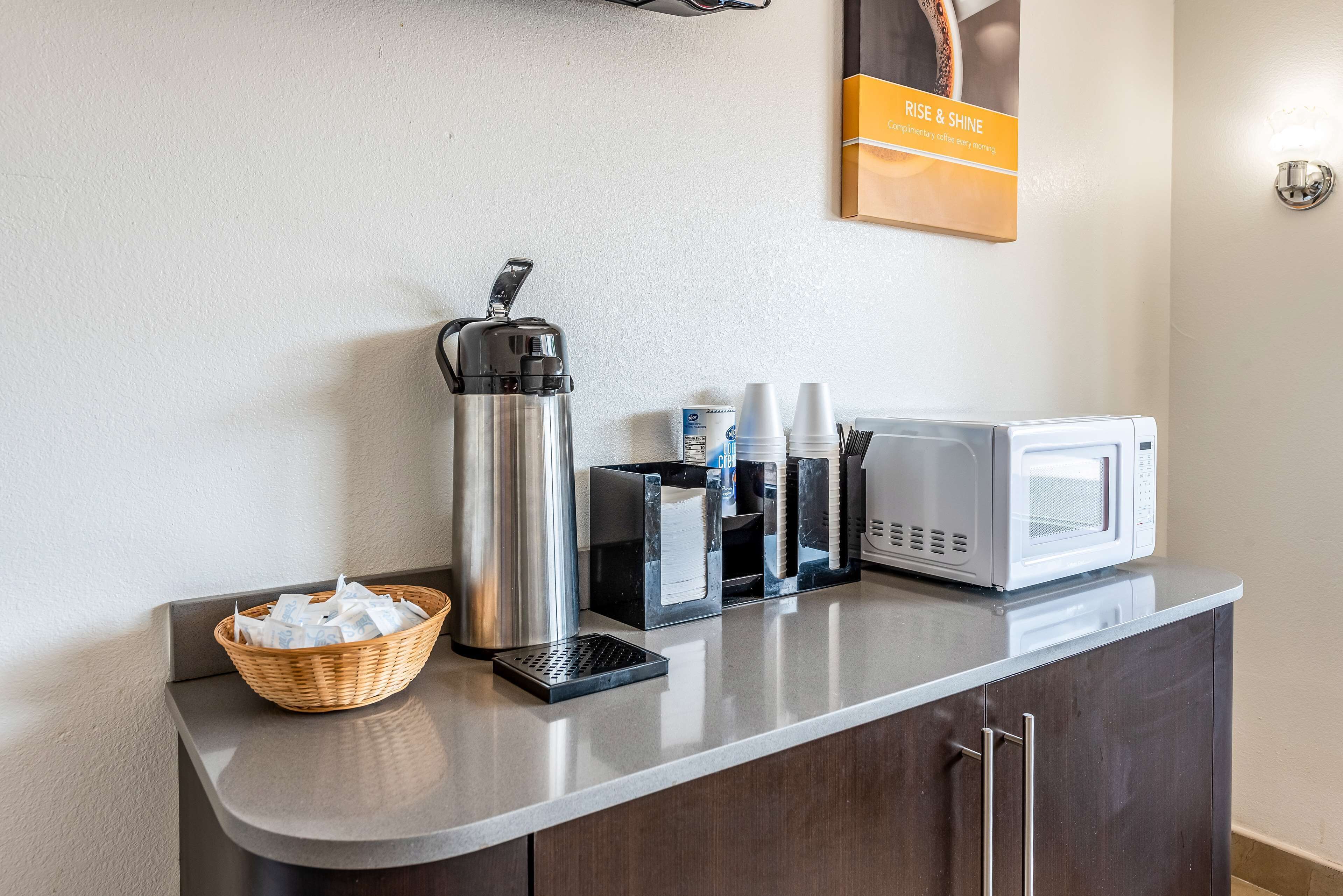 Eine Küchenzeile mit Kaffeemaschine, Mikrowelle und Gewürzspendern auf einer Arbeitsplatte.