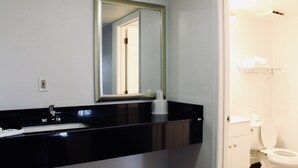 A bathroom with a black sink, a mirror, a toilet, and a towel rack. - Motel 6 - Dayton, OH (Dayton)