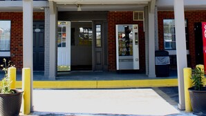 A motel with a prominent '6' sign, a covered entrance, and a vending machine. - Motel 6 - Dayton, OH (Dayton)