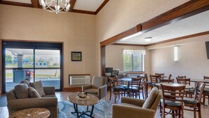A hotel lobby with a seating area, a reception desk, and a view of the outside. - Quality Inn Meadville (Meadville)