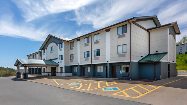 A multi-story hotel with a covered entrance, handicap parking, and a flat roof.