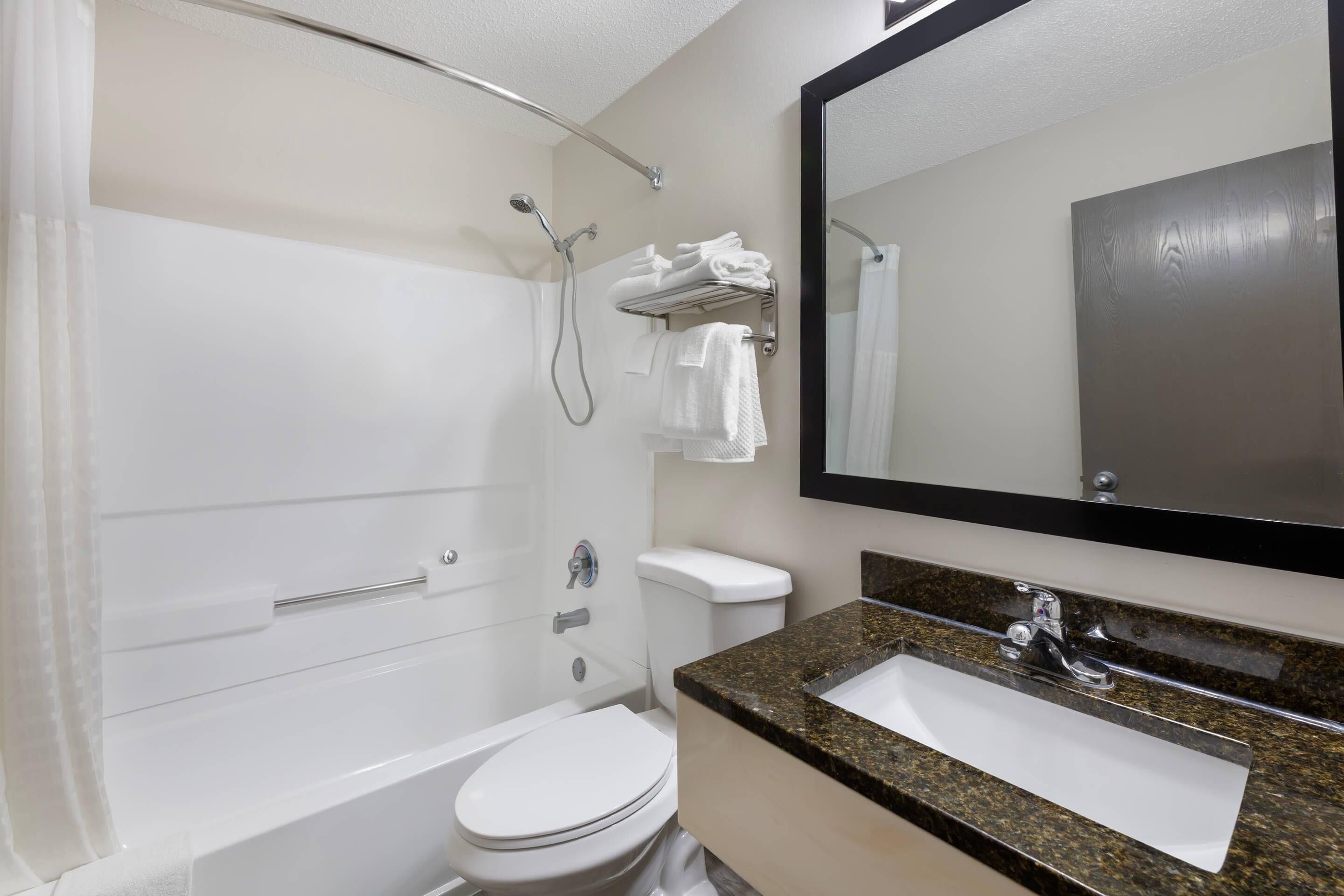 Une salle de bain équipée d’une baignoire, de toilettes, d’un lavabo et d’un miroir.