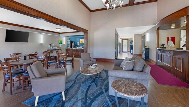 A spacious living area with a dining set, sofas, a coffee table, and a kitchen area in the background. - Quality Inn Meadville (Meadville)