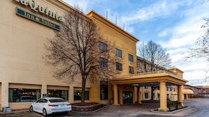 A hotel named LaQuinta Inn & Suites with a yellow facade, a covered entrance, and a parking area.