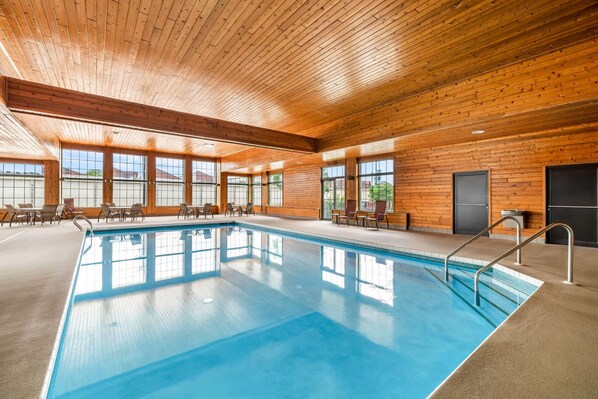 Una piscina techada, sillones reclinables de piscina