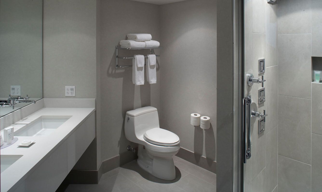 A modern bathroom with a toilet, a sink, and a shower.