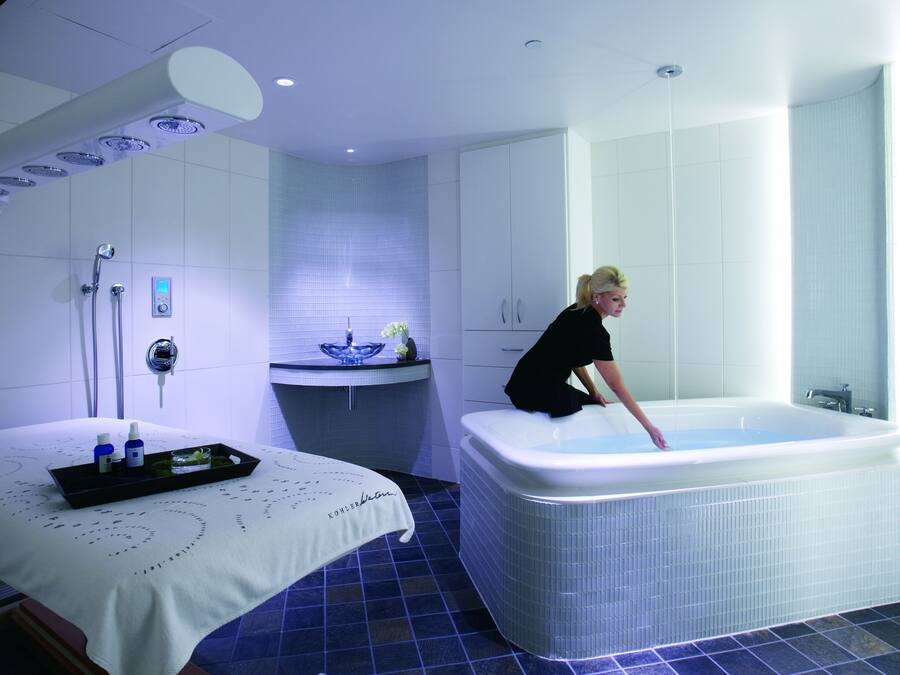 A modern bathroom with a large bathtub, a separate shower area, and a vanity with a sink.