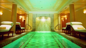A spa area with a green heated floor, a ceiling with a cloud mural, and two relaxation chairs on either side. - Inn On Woodlake (Kohler)