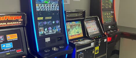 A row of gaming machines in a room with a tiled floor.