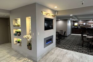 Relax in the stylish lobby, featuring a reception area, TV, and cozy seating.