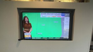 A television mounted on a wall displaying a weather forecast. - La Quinta Inn and Suites by Wyndham Cincinnati North (Cincinnati)