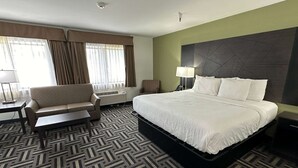 A hotel room with a large bed, a sofa, a desk, and a chair. - La Quinta Inn and Suites by Wyndham Cincinnati North (Cincinnati)