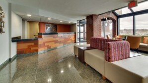 A lobby with a reception desk, seating area, and large windows. - Pear Tree Inn St. Louis Arnold (Arnold)