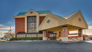 A modern building with a prominent entrance, large windows, and a covered parking area. - Pear Tree Inn St. Louis Arnold (Arnold)