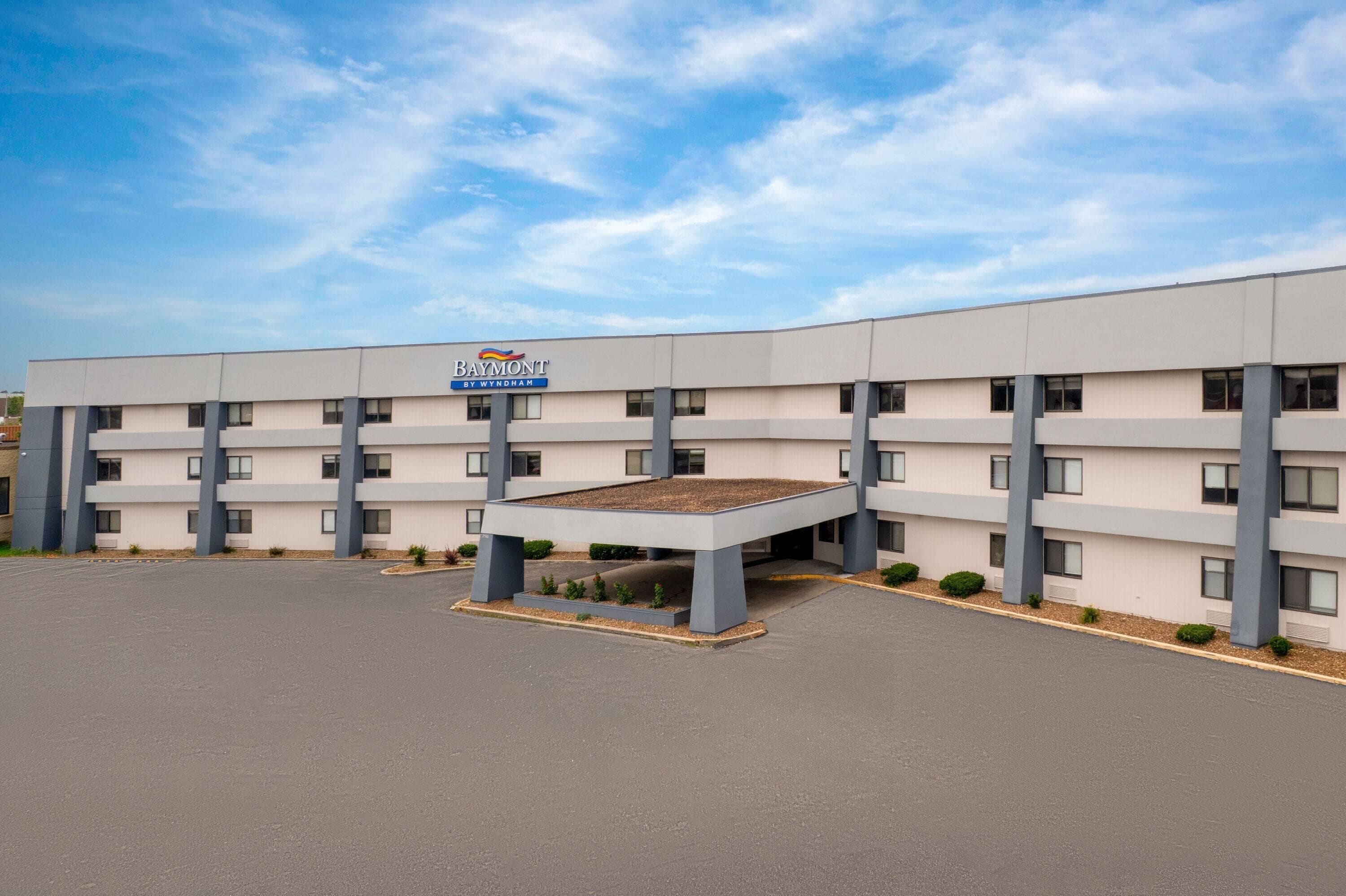 Un immeuble d’hôtel à plusieurs étages, doté d’un toit plat et d’un espace d’entrée abrité.