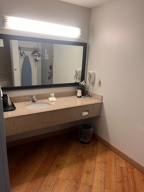 A bathroom with a sink, mirror, and hairdryer. - Baymont by Wyndham Columbia, MO (Columbia)