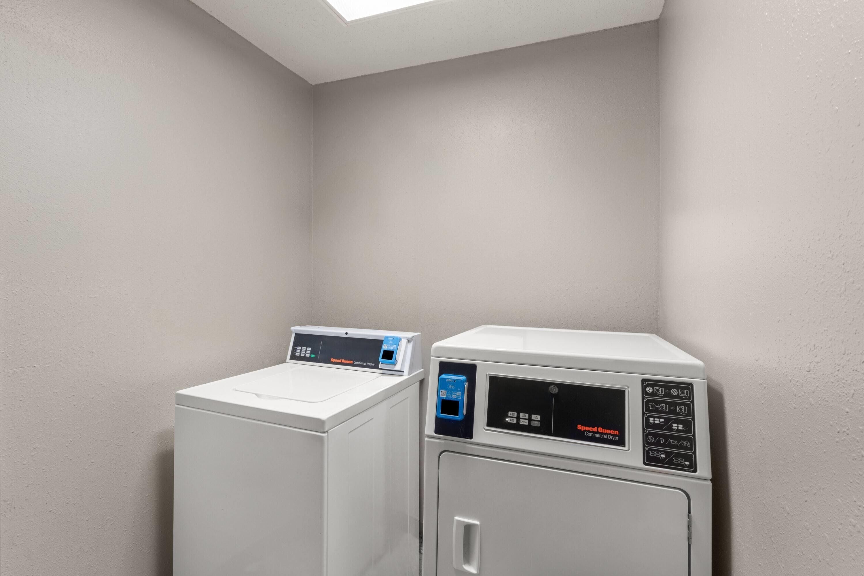 A laundry area with a commercial washer and dryer.