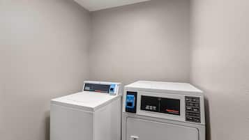 A laundry area with a commercial washer and dryer.