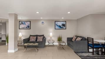 A modern living room with two sofas, a coffee table, and a dining area with a table and chairs.