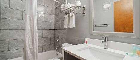 A modern bathroom with a bathtub, toilet, and sink.