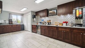 A modern kitchen with dark wooden cabinets, a tiled backsplash, and a built-in refrigerator.